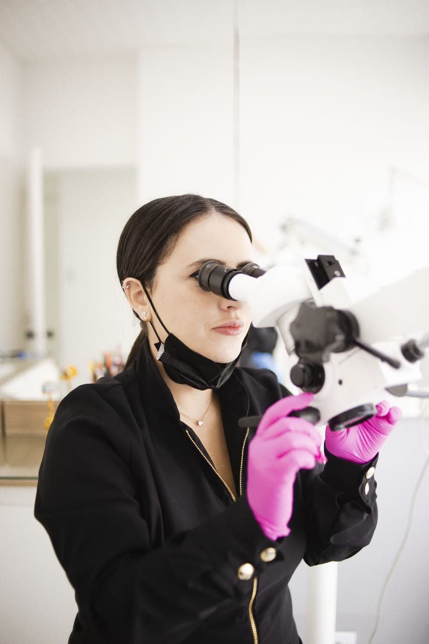 Dra. Natalia Sampaio em atendimento com microscópio operatório